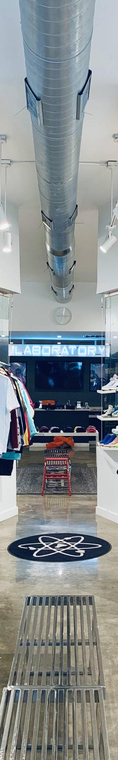 The interior of The Laboratory DTX sneaker shop, with sneakers and apparel displayed along bright white walls