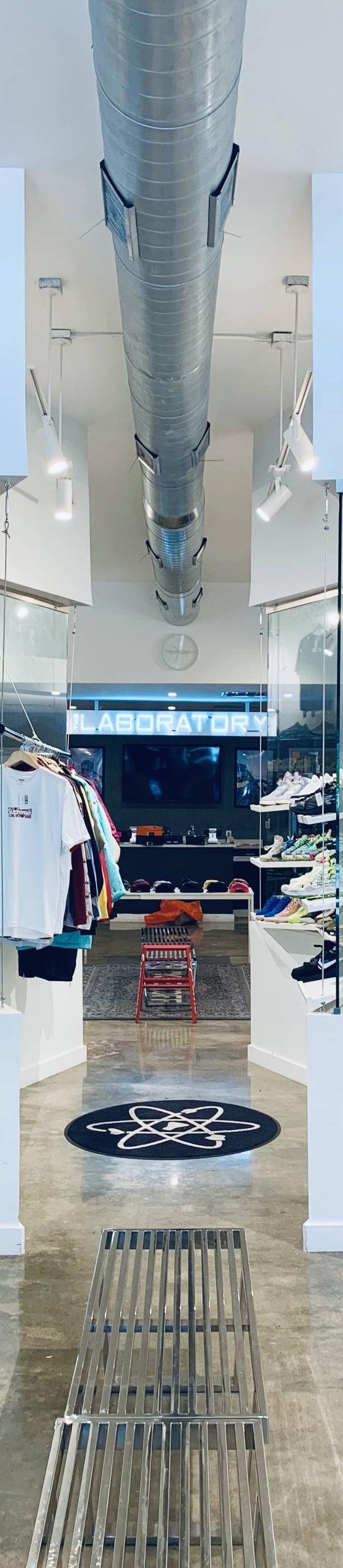 The interior of The Laboratory DTX sneaker shop, with sneakers and apparel displayed along bright white walls