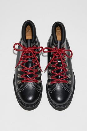 A pair of black TOGA Archives leather hiking boots with metal hardware and red laces