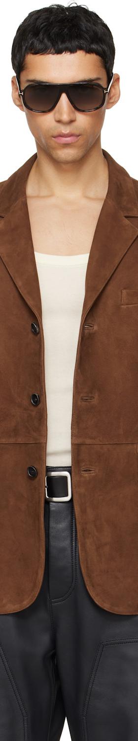 A man wearing a brown suede TONYWACK blazer with sunglasses and black leather trousers