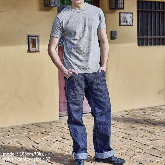 A man wearing UES selvedge denim work trousers with a grey heather tee