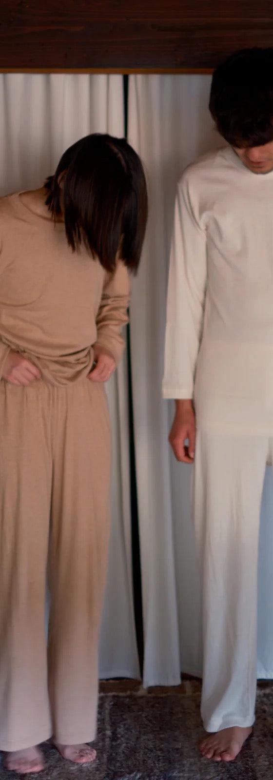 Two models wearing undyed cream and natural tan long-sleeve tops and wide-leg pants