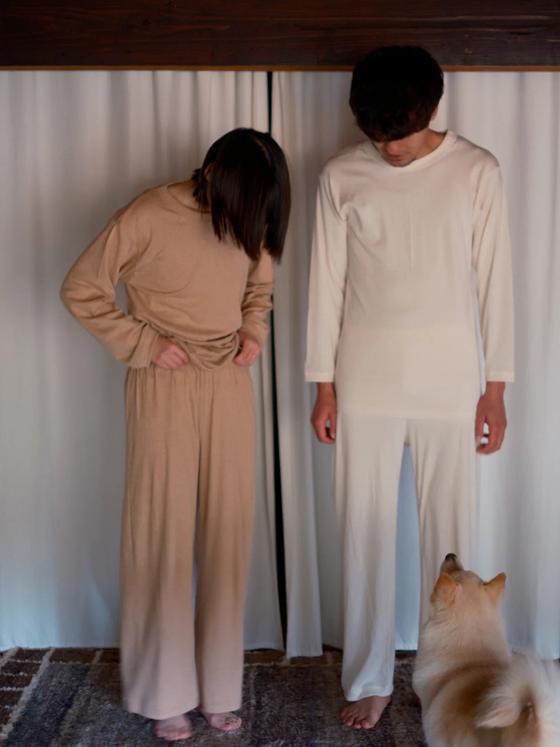 Two models wearing undyed cream and natural tan long-sleeve tops and wide-leg pants