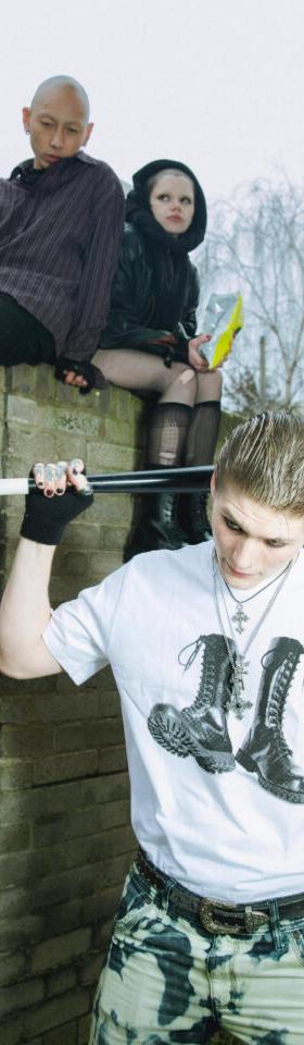 Three people in punk streetwear and black lace-up Underground England boots on a brick wall