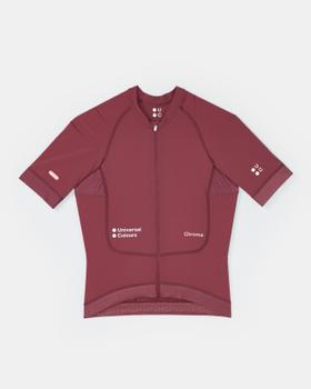 A burgundy Universal Colours Chroma short-sleeve cycling jersey laid flat on a soft grey background