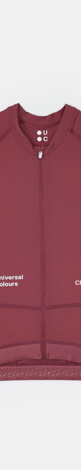 A burgundy Universal Colours Chroma short-sleeve cycling jersey laid flat on a soft grey background