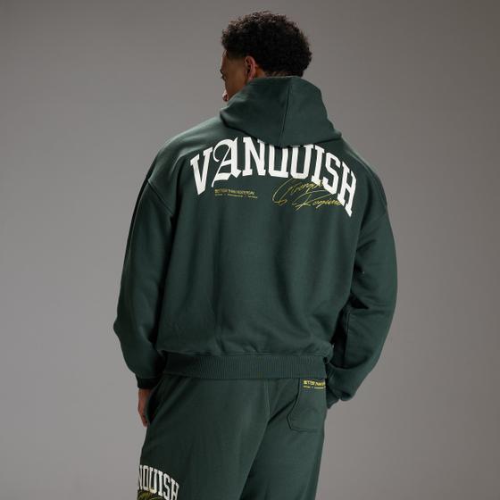 A man wearing a dark green Vanquish Fitness hoodie and matching joggers, shot from behind