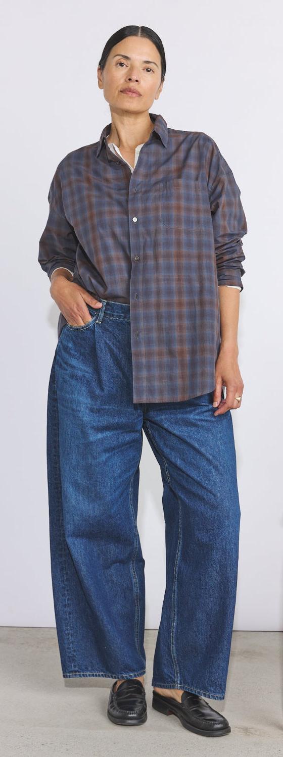 A woman wearing a checked Véritécoeur shirt with wide-leg denim jeans