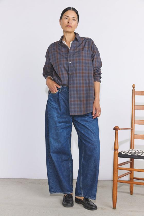 A woman wearing a checked Véritécoeur shirt with wide-leg denim jeans