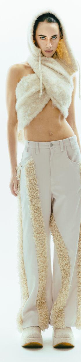 A woman wearing a cream faux-fur hooded scarf and fur-panelled ViaVanda trousers