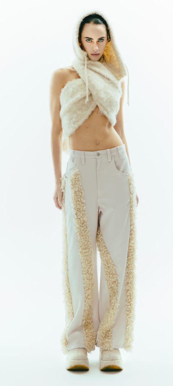 A woman wearing a cream faux-fur hooded scarf and fur-panelled ViaVanda trousers
