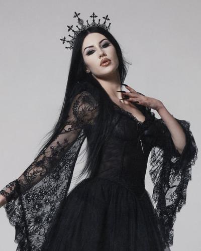 A woman wearing a black lace Widow gown with a cross crown