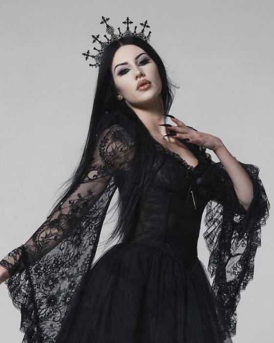 A woman wearing a black lace Widow gown with a cross crown
