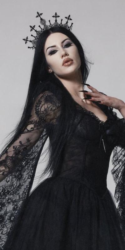 A woman wearing a black lace Widow gown with a cross crown