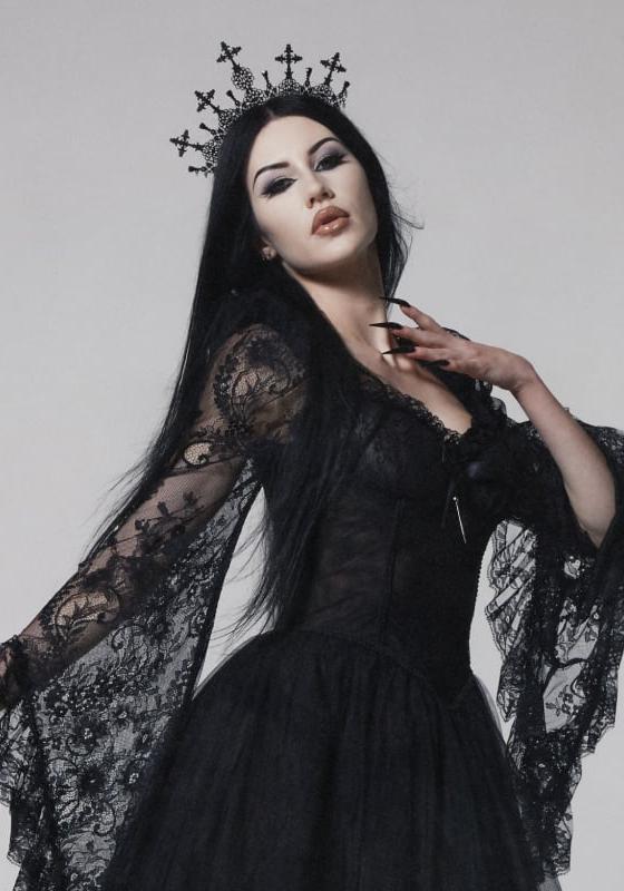 A woman wearing a black lace Widow gown with a cross crown