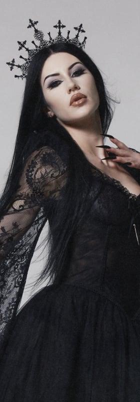 A woman wearing a black lace Widow gown with a cross crown