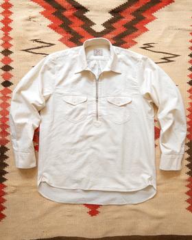 A cream Wythe half-zip popover workshirt laid flat on a woven Southwestern blanket