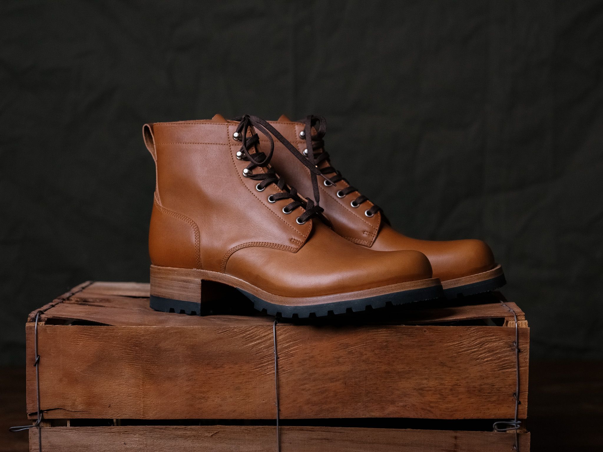 A pair of Saddleback Huntsman boots in Natural leather on a wooden crate, side view