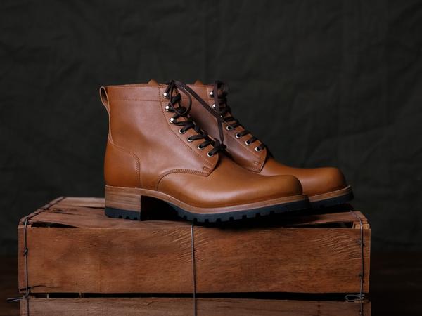 A pair of Saddleback Huntsman boots in Natural leather on a wooden crate, side view
