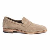 A single taupe suede penny loafer shown in side profile on a plain white background, with a moc-toe stitched apron, a penny strap, a natural leather sole with a stitched welt, and a stacked leather heel.