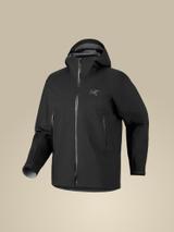A black Arc'teryx Beta shell jacket shown on an invisible mannequin in three-quarter front view against a warm beige background, with the hood up, a full-length centre zip, two vertical zipped hand pockets and a tonal grey bird logo on the chest.